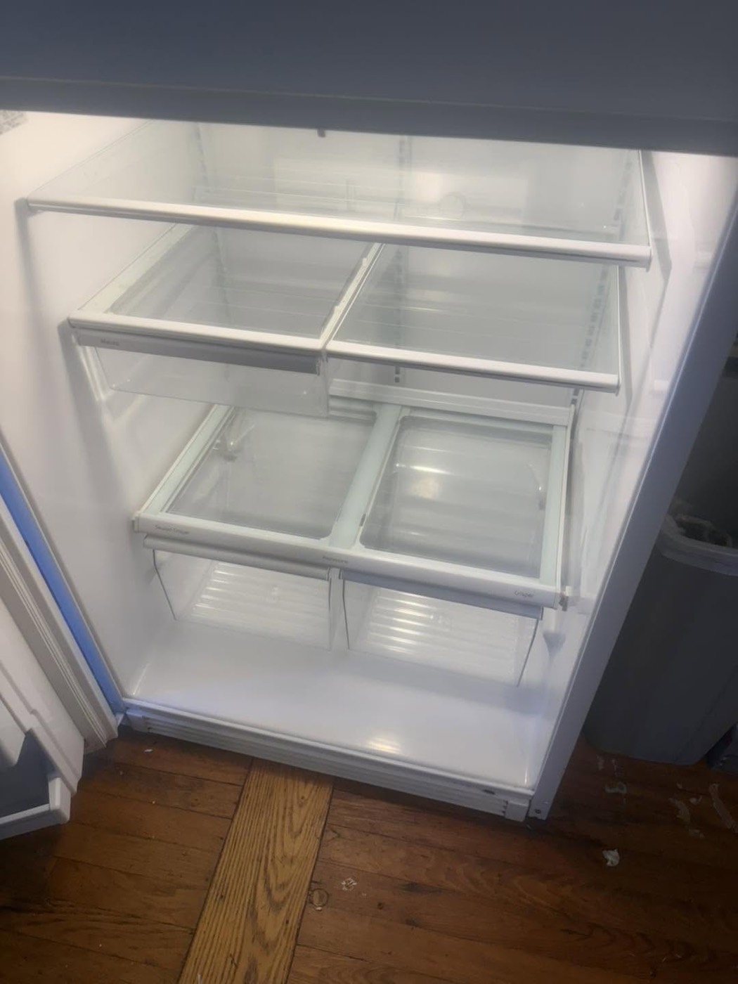 The same refrigerator interior after cleaning, shelves wiped clean