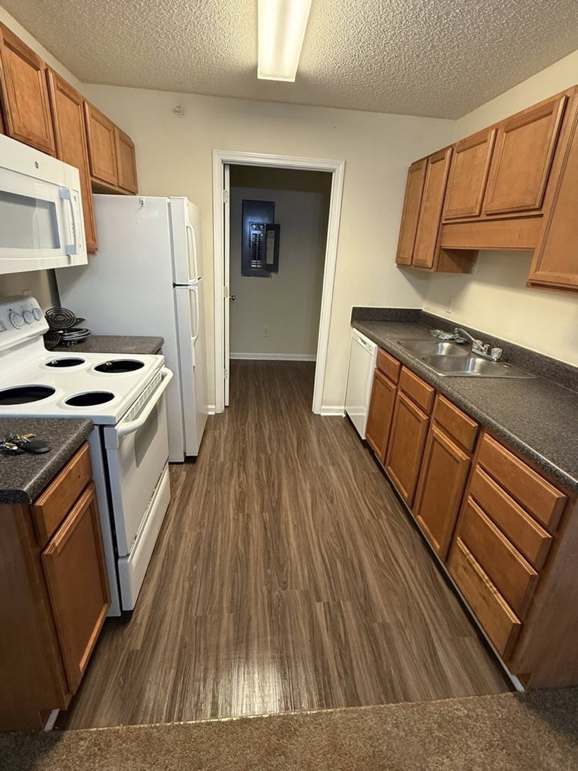 The same apartment kitchen after cleaning, floors clear and surfaces wiped